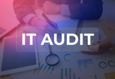 IT audit concept showing business people reviewing charts, laptop and magnifying glass on a desk to illustrate IT audit process.